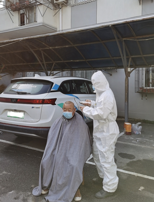 全副武装的“Tony老师”正在为社区抗疫志愿者理发.jpg